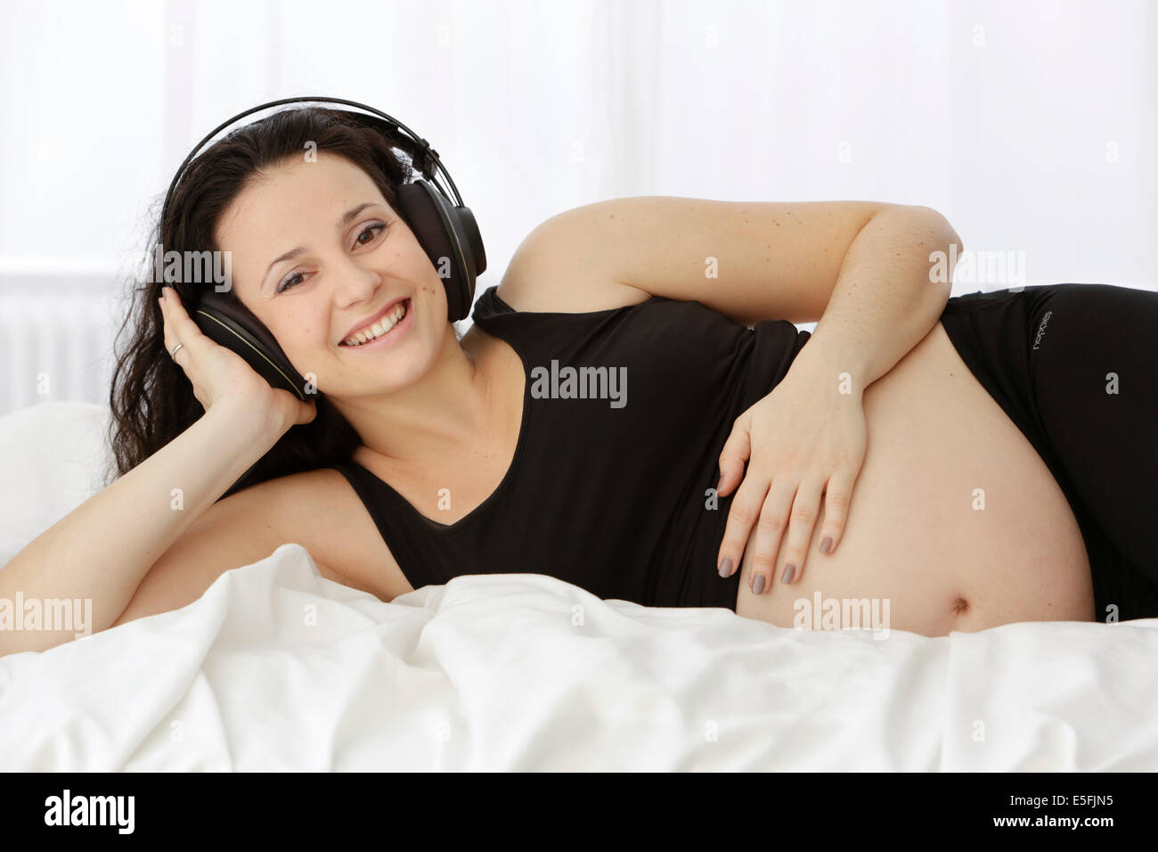 Schwangere Frau Musik hören Stockfoto