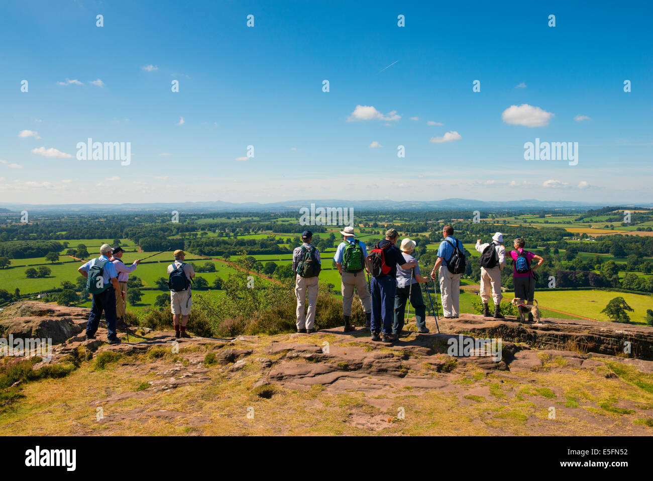 Eine Gruppe von Wanderern blicken auf North Shropshire Landschaft von Grinshill Hill, Shropshire, England Stockfoto