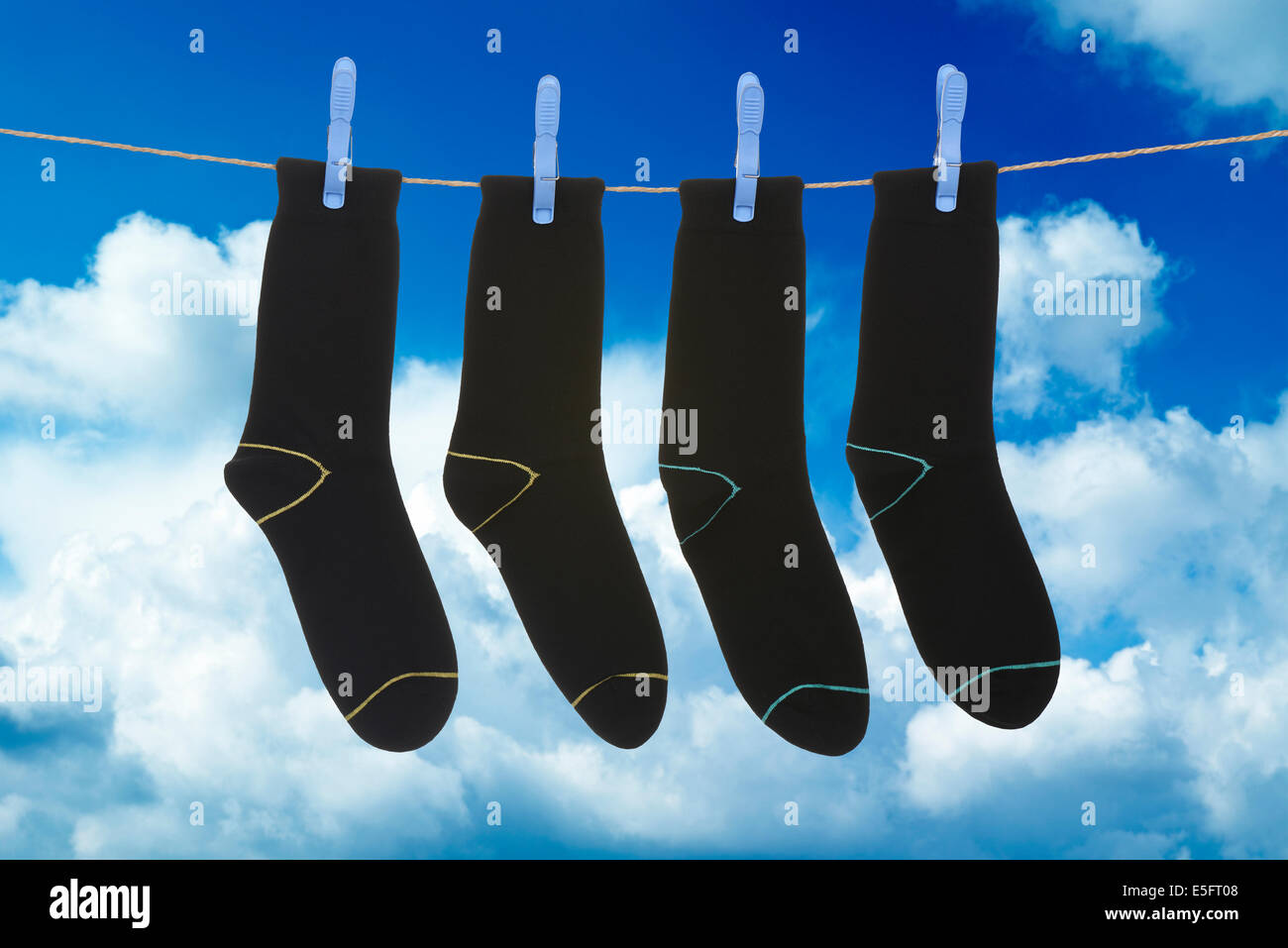 Socken hängen zum Trocknen über blauen Wolkenhimmel Stockfoto