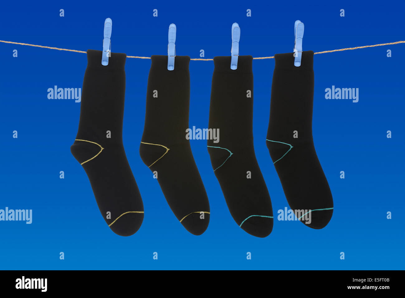 Socken hängen zum Trocknen über klaren, blauen Himmel Stockfoto