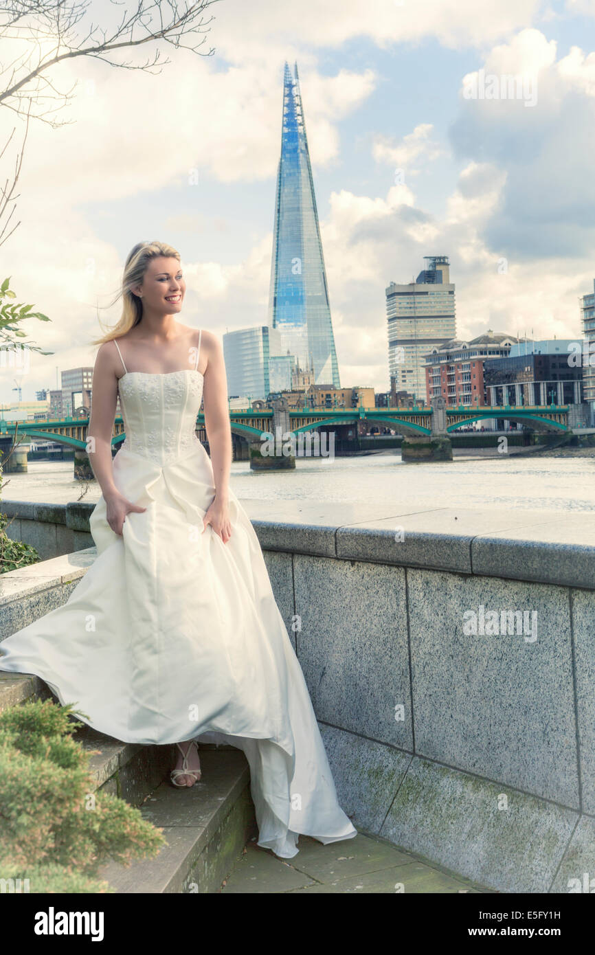 Eine Braut steht auf dem nördlichen Ufer der Themse in London mit dem Shard hinter London, England, UK Stockfoto