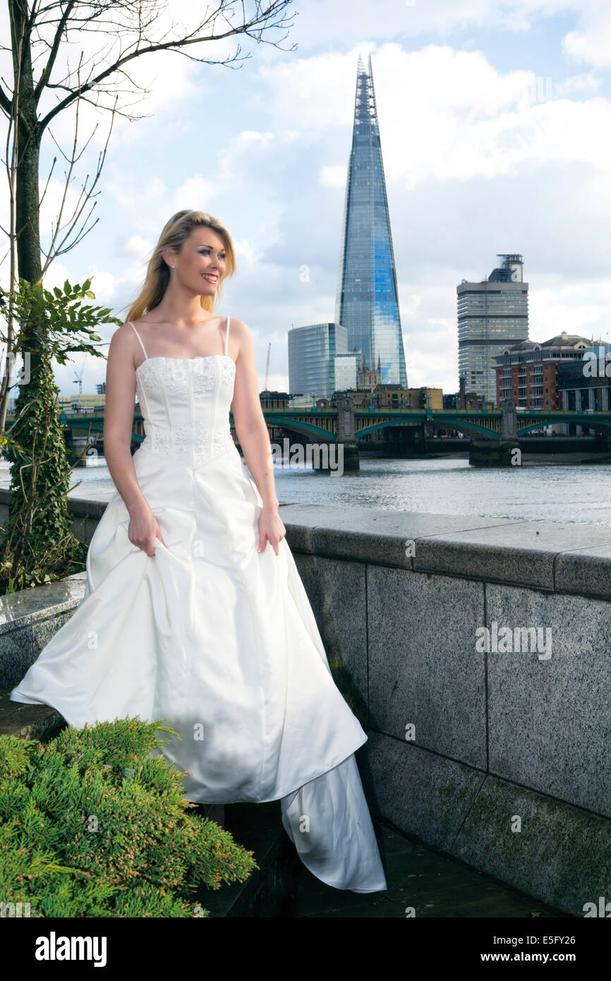 Eine Braut steht auf dem nördlichen Ufer der Themse in London mit dem Shard hinter London, England, UK Stockfoto