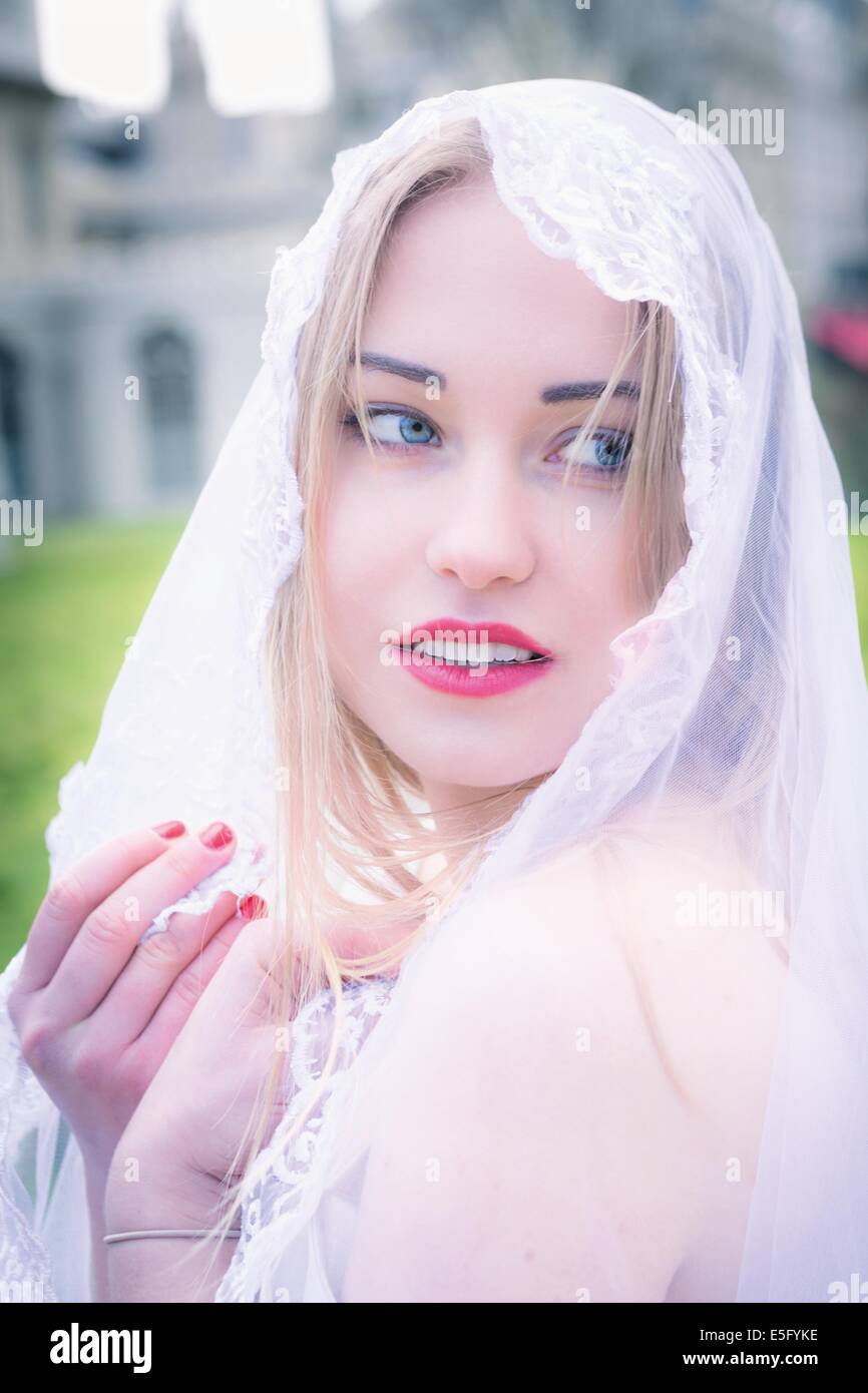 Eine schöne junge Frau mit blauen Augen tragen einen Brautschleier Stockfoto