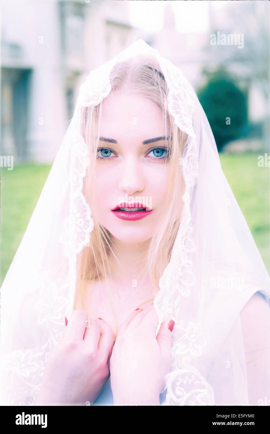 Eine schöne junge Frau mit blauen Augen tragen einen Brautschleier Stockfoto