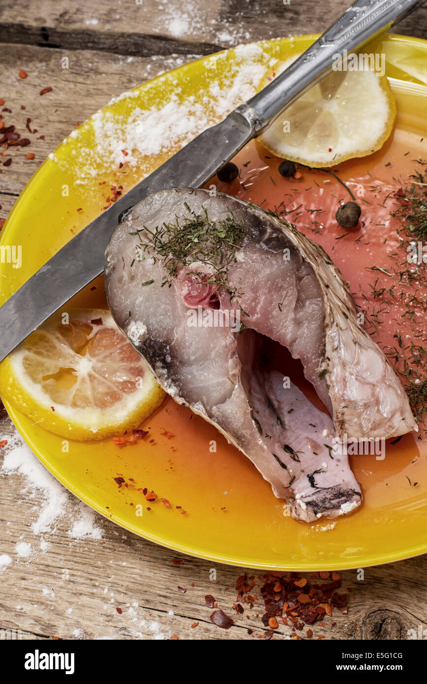 gebackener Fisch in einer stilvollen Platte auf hölzernen Hintergrund Stockfoto