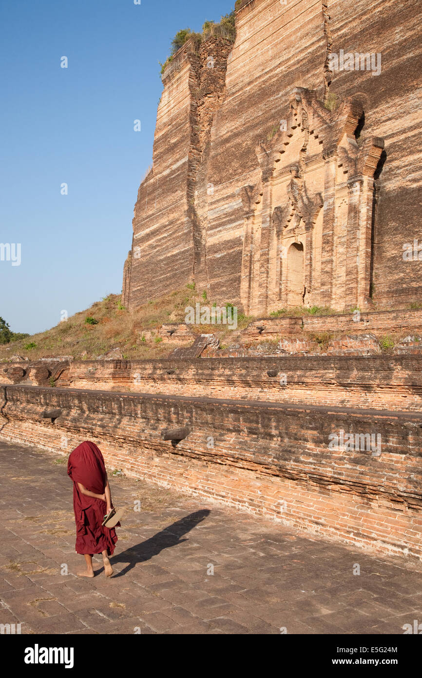 Ein junge Mönch geht die gigantische unvollendete Mingun Paya Stupa MIngun, in der Nähe von Mandalay Region, Birma (Myanmar). Stockfoto