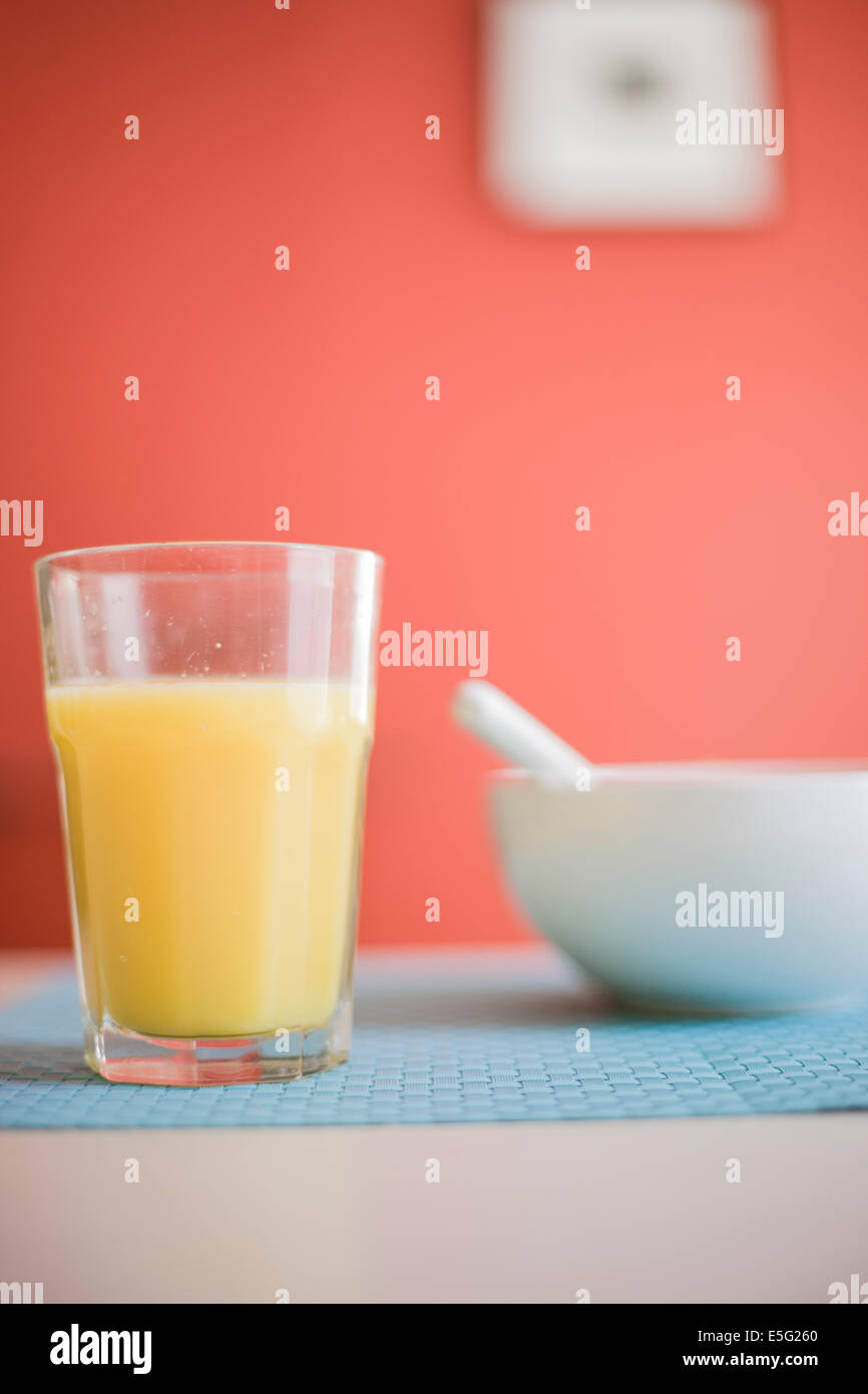 Orangensaft und Schale am Tisch Stockfoto