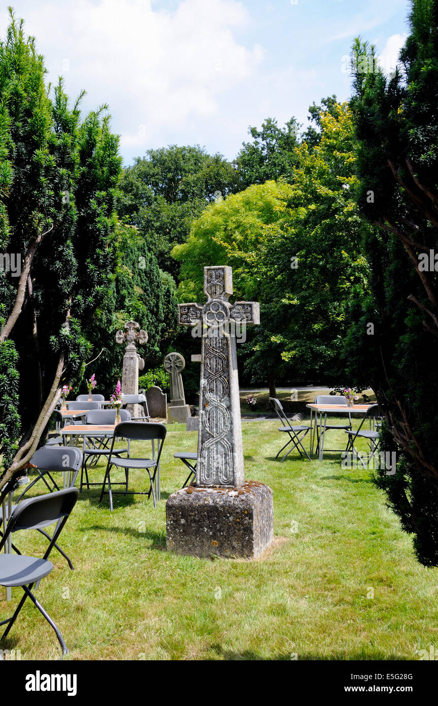 Keltisches Kreuz umgeben von Tischen und Stühlen im Kirchhof von Str. Marys Kirche, Bayford Hertfordshire Stockfoto