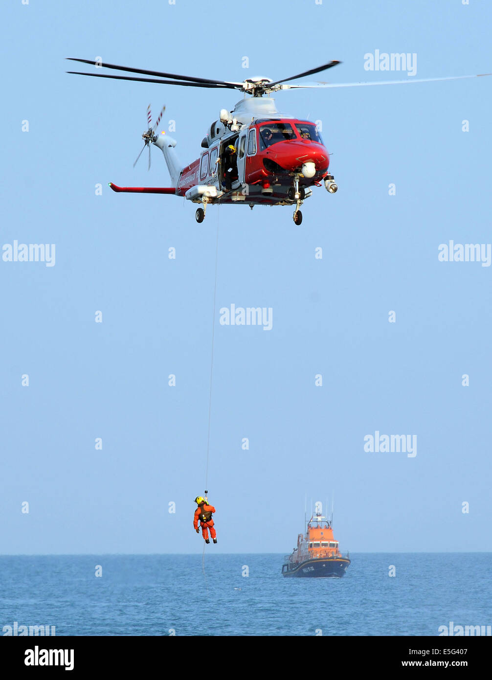 Küstenwache-Search and Rescue Helikopter, Winde Mann und RNLI-Rettungsboot, England, UK Stockfoto