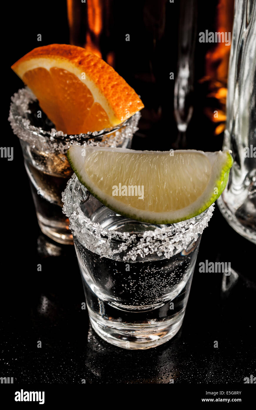 Gold Tequila mit Orange und Zitrone und Zimt auf reflektieren Hintergrund Stockfoto