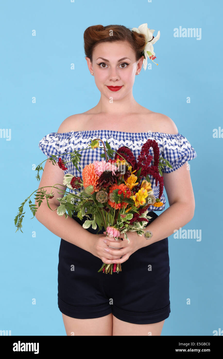 Frau in einem "Gingham" Oberseite hält einen Blumenstrauß Stockfoto