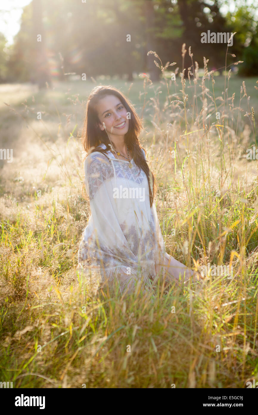 Eine junge Frau mit braunen Haaren in ihren Zwanzigern Relaxen im Hyde Park/Kensington Gardens in London im Sommer Stockfoto