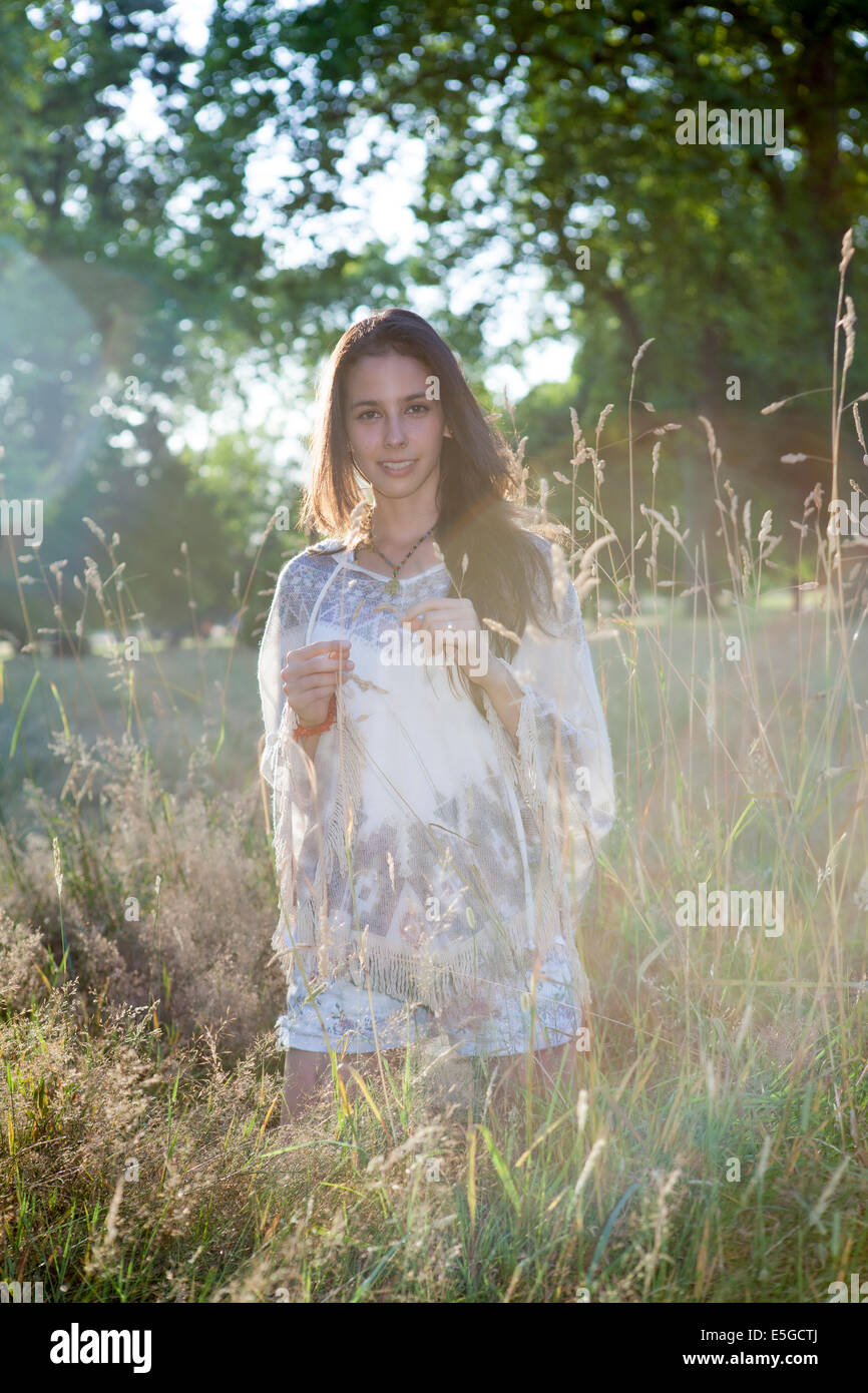 Eine junge Frau mit braunen Haaren in ihren Zwanzigern Relaxen im Hyde Park/Kensington Gardens in London im Sommer Stockfoto