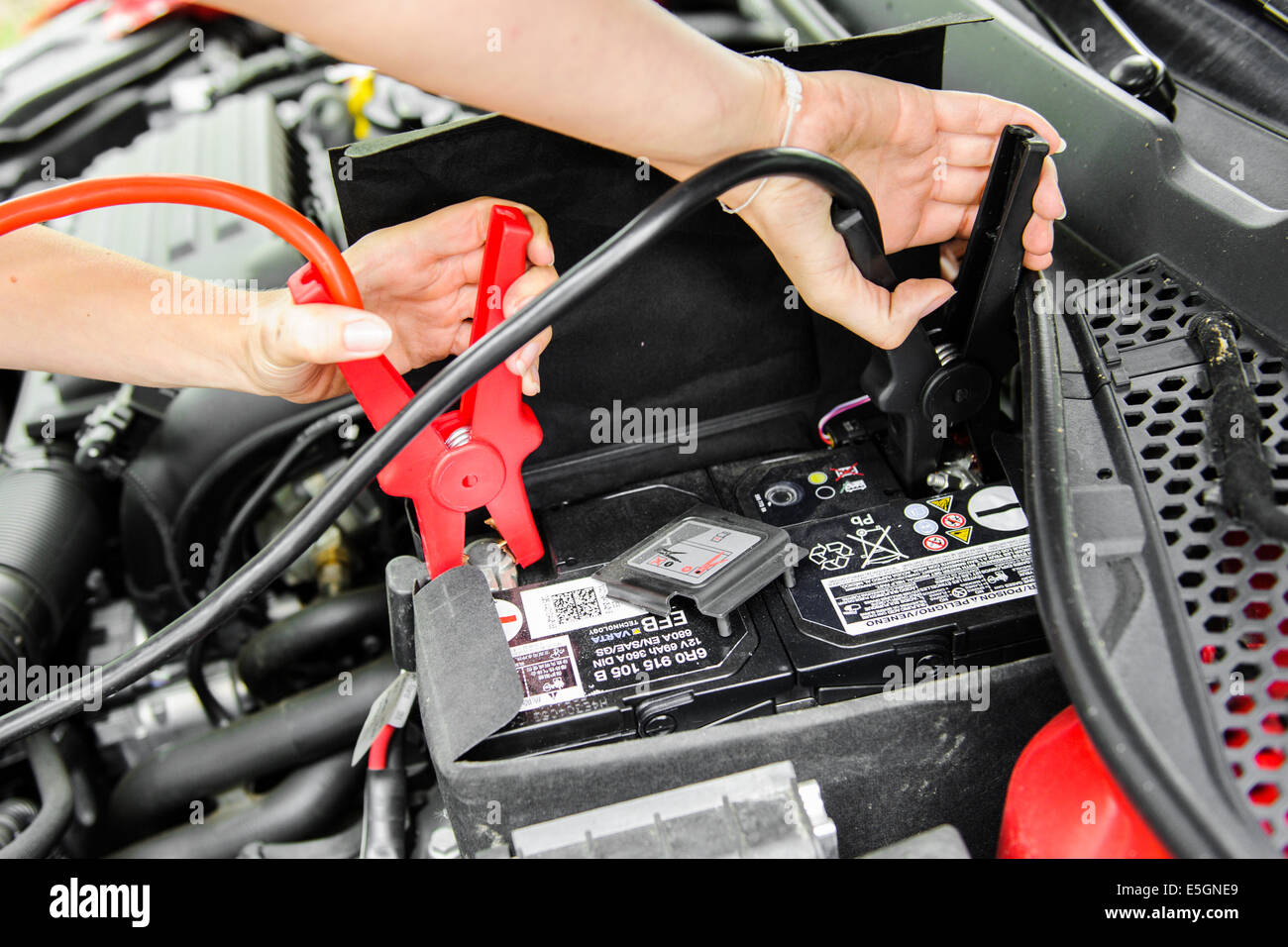 Eine junge Frau ändert sich eine Rad auf ein Auto. Foto: picture Alliance/Robert Schlesinger/Picture alliance Stockfoto