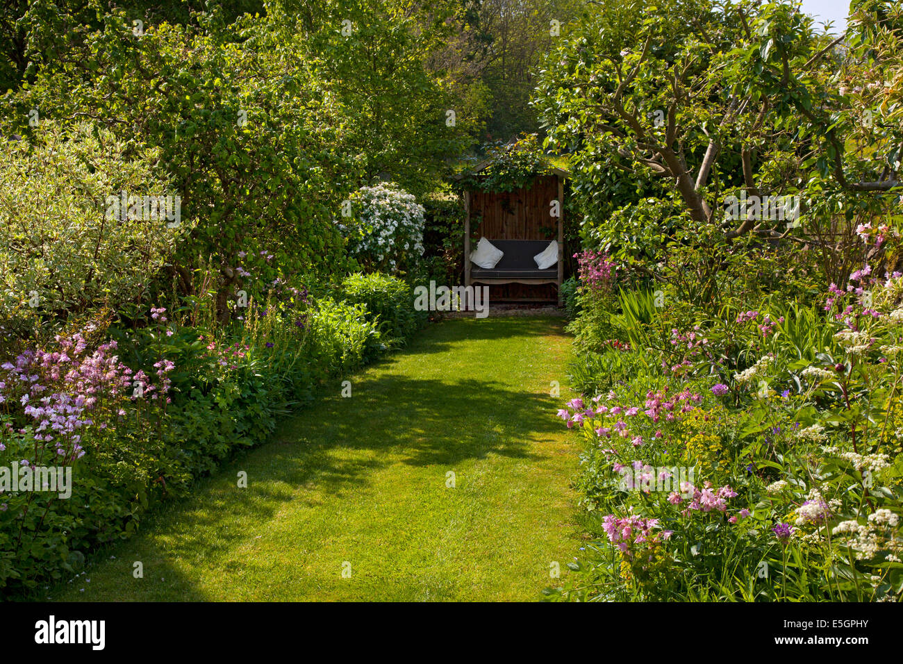 Blick hinunter Rasen Weg, schattige Pergola aus Holz im englischen Garten Stockfoto