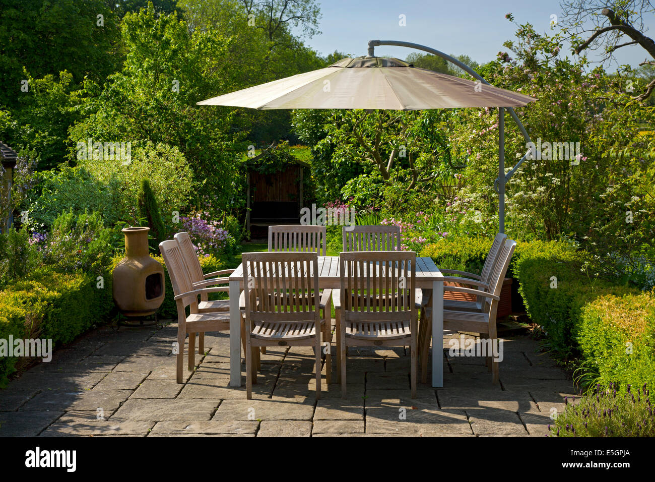 Essbereich mit Tisch und Stühlen im englischen Garten Outdoor Stockfoto