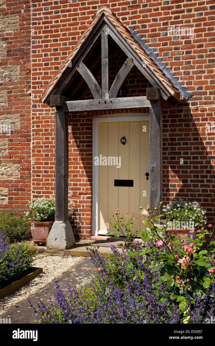 Vordere Veranda und Tor des englischen Bauernhaus mit Pfad und Cottage Garten Stockfoto