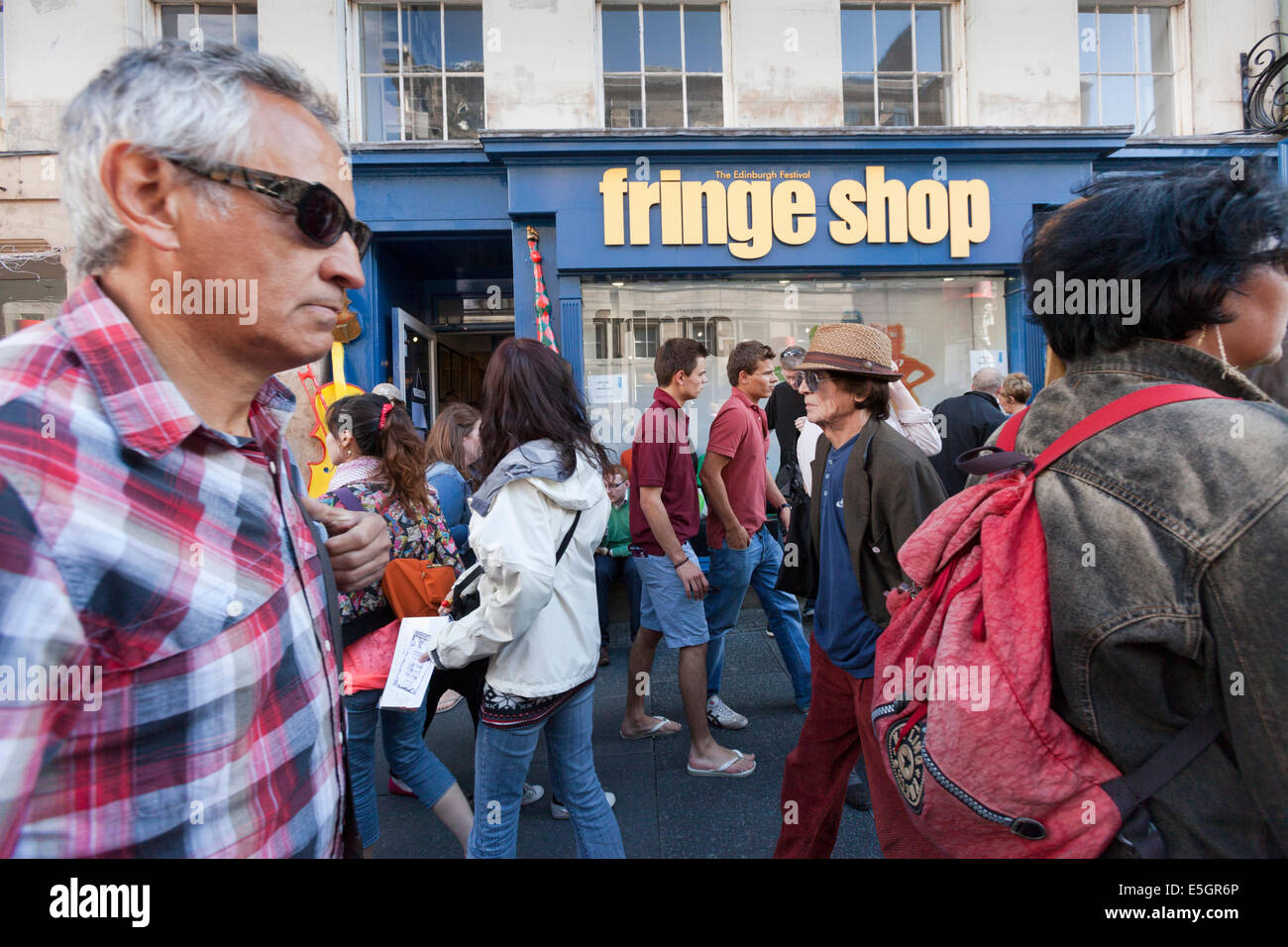 Festival-Besucher passieren das Edinburgh Fringe-Shop in der Stadt High Street. Stockfoto