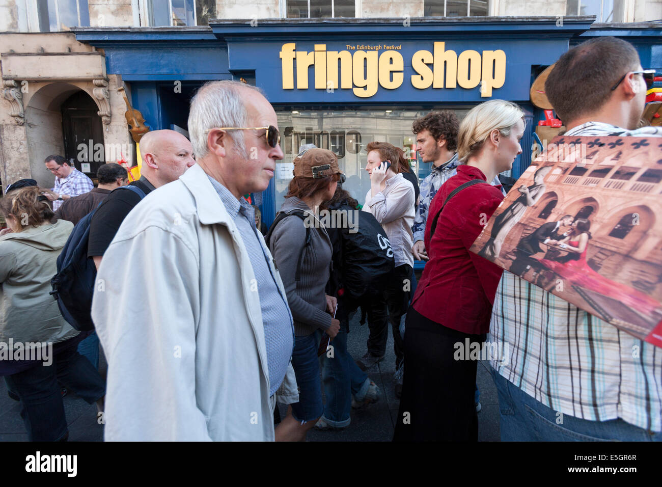 Festival-Besucher passieren das Edinburgh Fringe-Shop in der Stadt High Street. Stockfoto