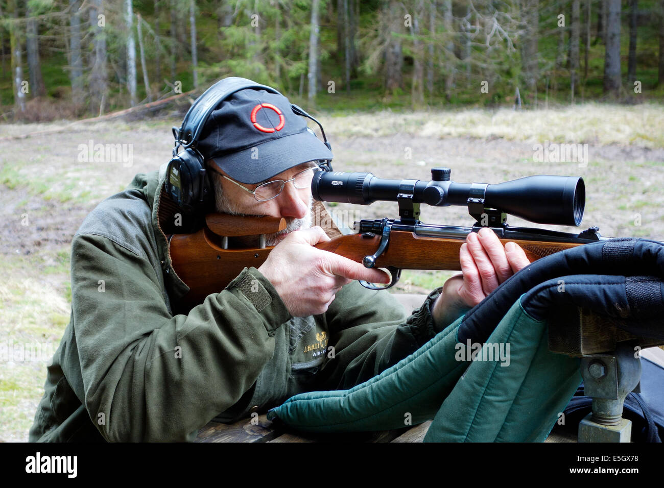 Ältere Jäger mit Jagdgewehr Mauser Aktion, ausgestattet mit einem Umfang soll ein Training Runden schießen. Stockfoto