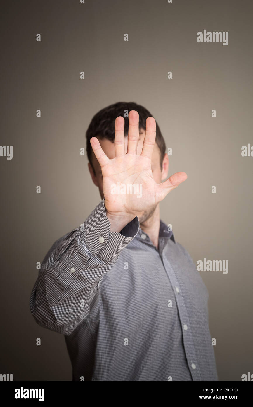 Kaukasischen Jüngling versteckt sein Gesicht mit der hand Stockfoto