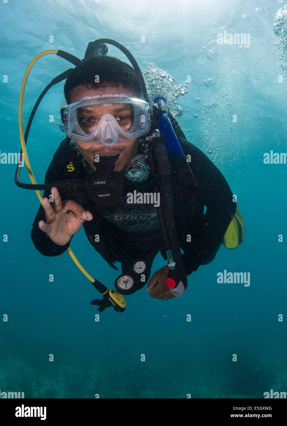 Belize Defense Force Petty Officer 3rd Class Abraham Hinds signalisiert den Blei-Taucher während eines Tauchgangs Training mit US-Segler Assi Stockfoto