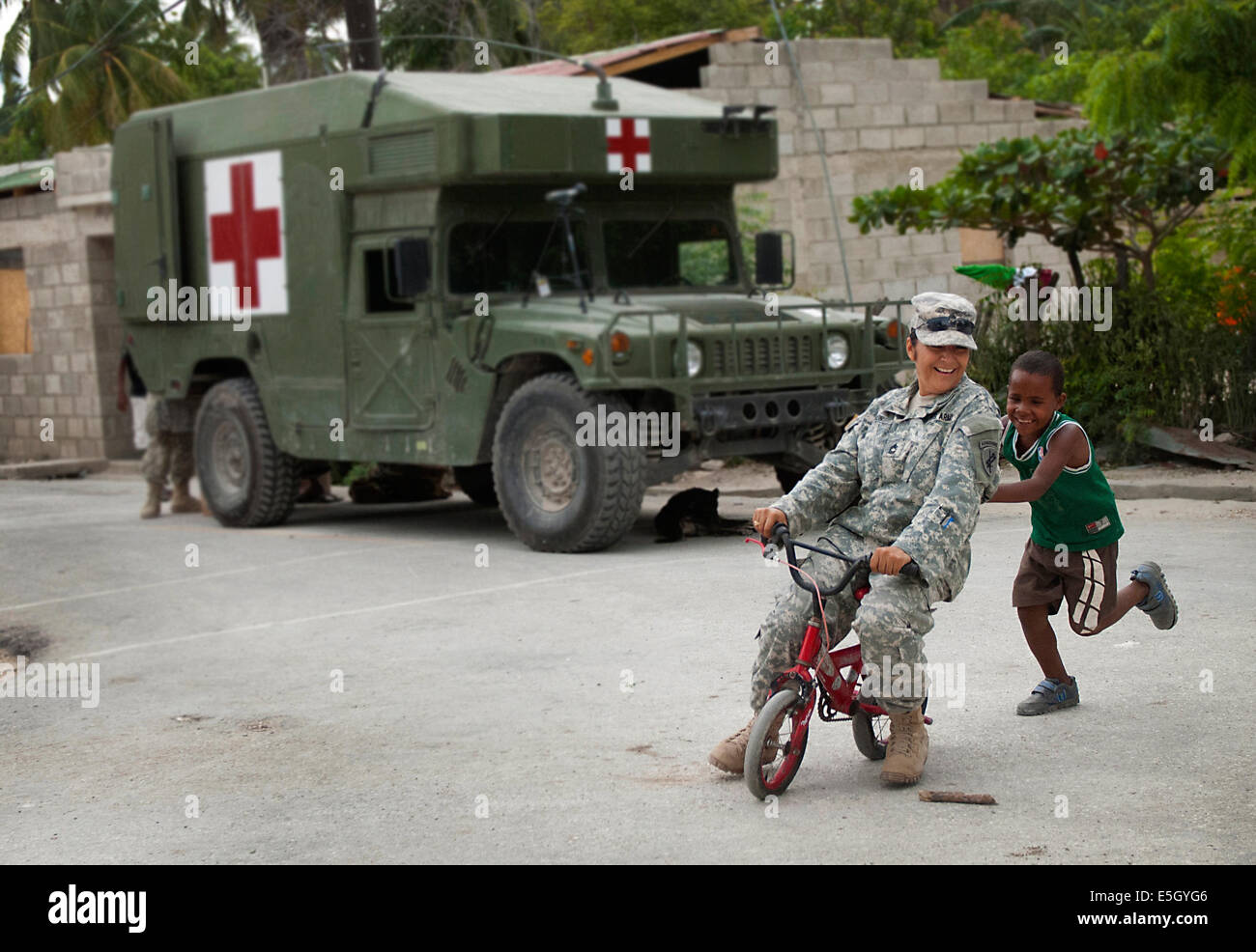 US Army Master Sgt. Elizabeth Limon, mit dem 486th Civil Affairs Bataillon, probiert einen jungen Fahrrad nahe dem Aufstellungsort von einem US-m Stockfoto