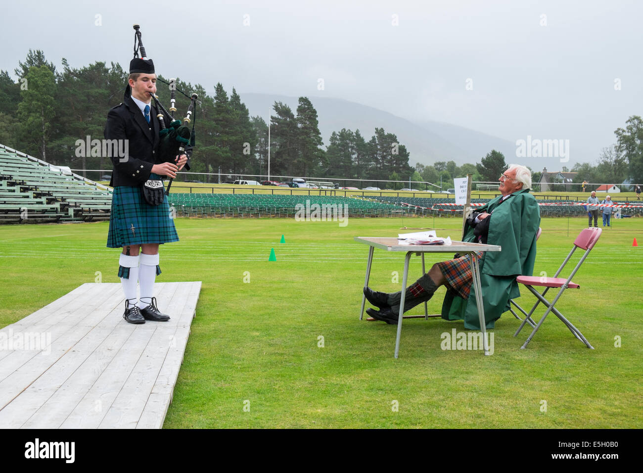 Piper und Richter beim Solo Piping Competition bei Braemar Junior Highland Games im Juli in Schottland, Vereinigtes Königreich Stockfoto