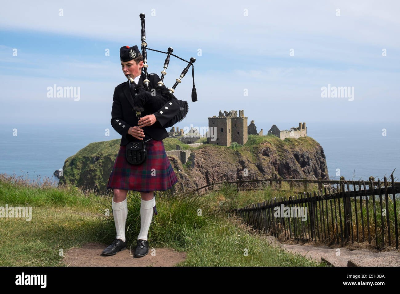 Piper spielt Dudelsäcke im traditionellen schottischen Kilt im Dunnottar Castle in der Nähe von Stonehaven in Aberdeenshire, Schottland, Großbritannien Stockfoto