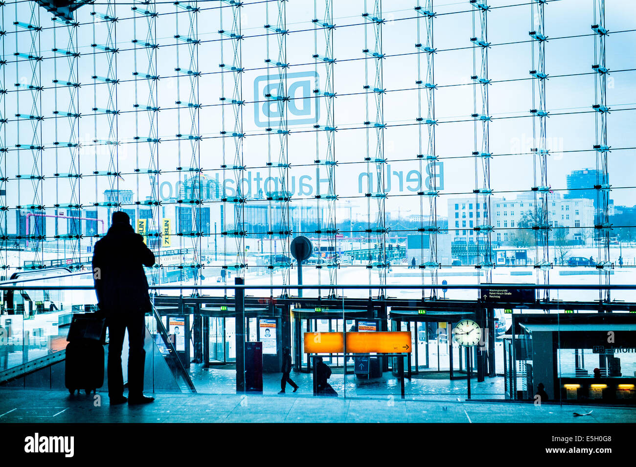 Geschäftsmann in der Silhouette mit Gepäck, machen auf dem Handy im Berliner Hauptbahnhof zu nennen. Stockfoto