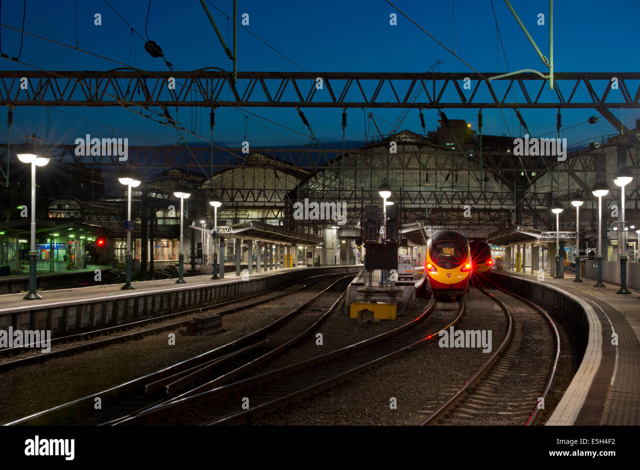 Das Ende der Plattformen der Bahnhof Manchester Piccadilly im Laufe des Abends auch einen Jungfrau Pendolino-Zug. Stockfoto
