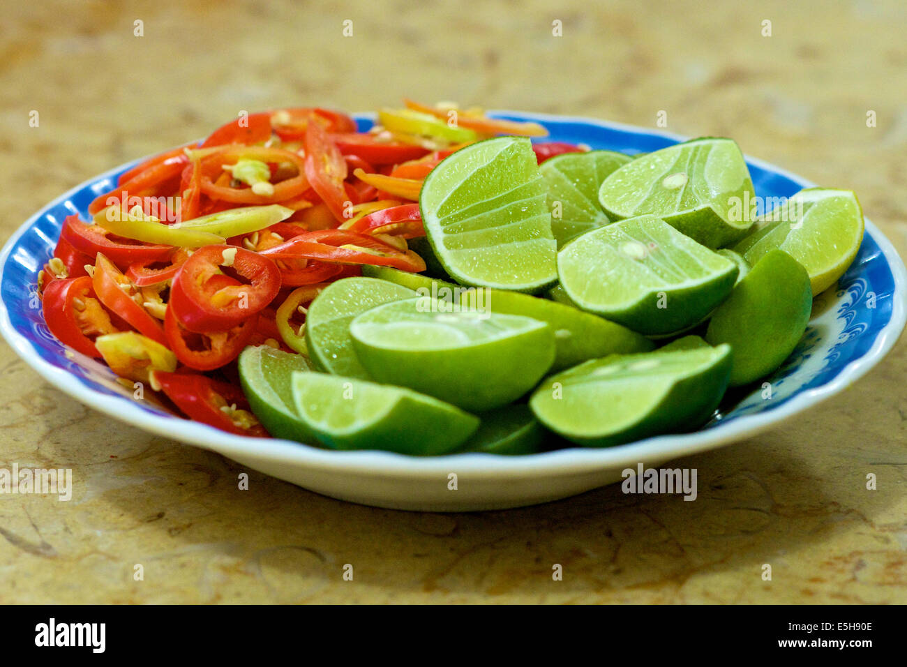 Teller mit grünen Limetten und rote hot chilly Peppers in Vietnam Stockfoto