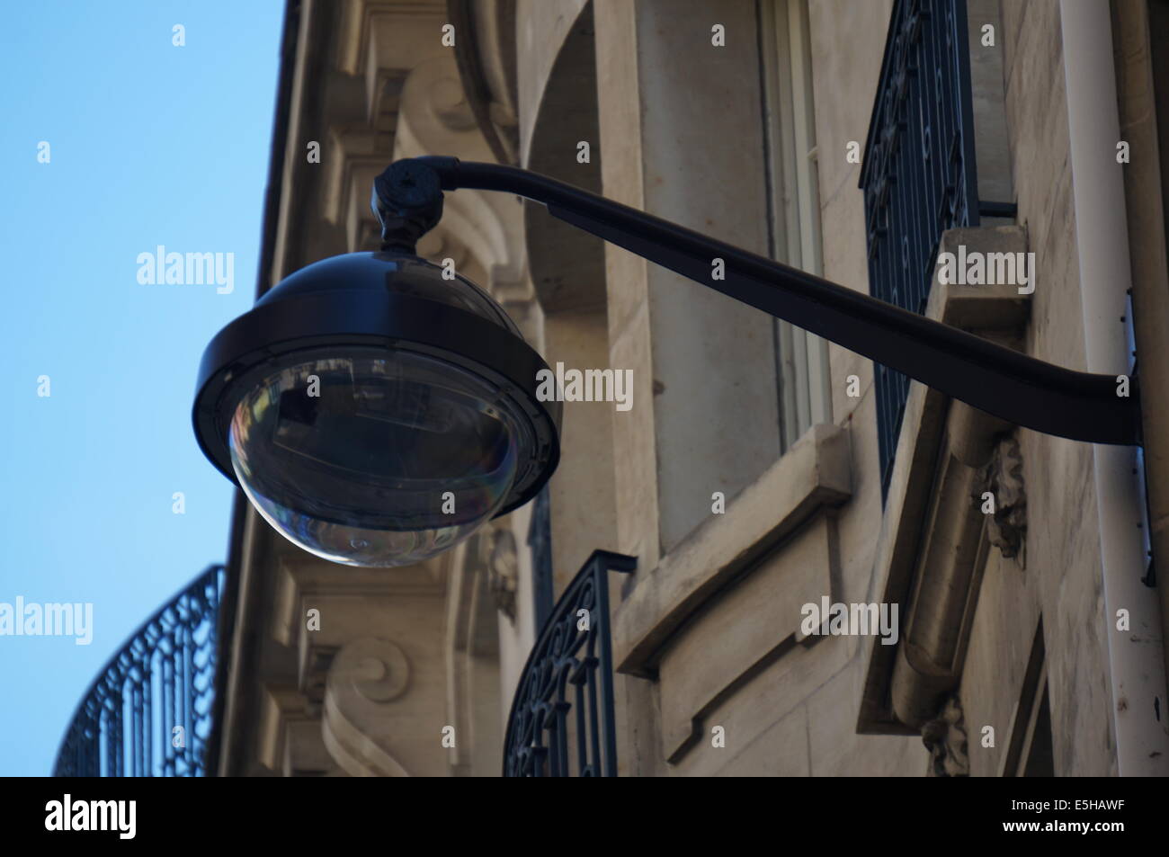 Ein Paris-Straßenlaterne erstreckt sich von einem Wohngebäude Stockfoto