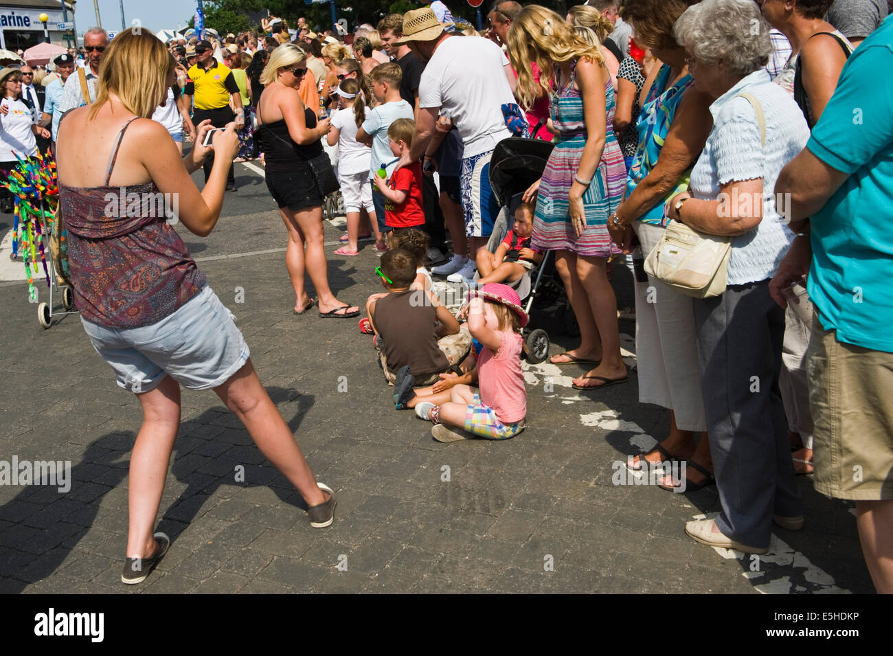 Frau mit Smartphone als Kamera zu fotografieren Kinder während Whitstable Oyster Festival Parade Kent England UK Stockfoto