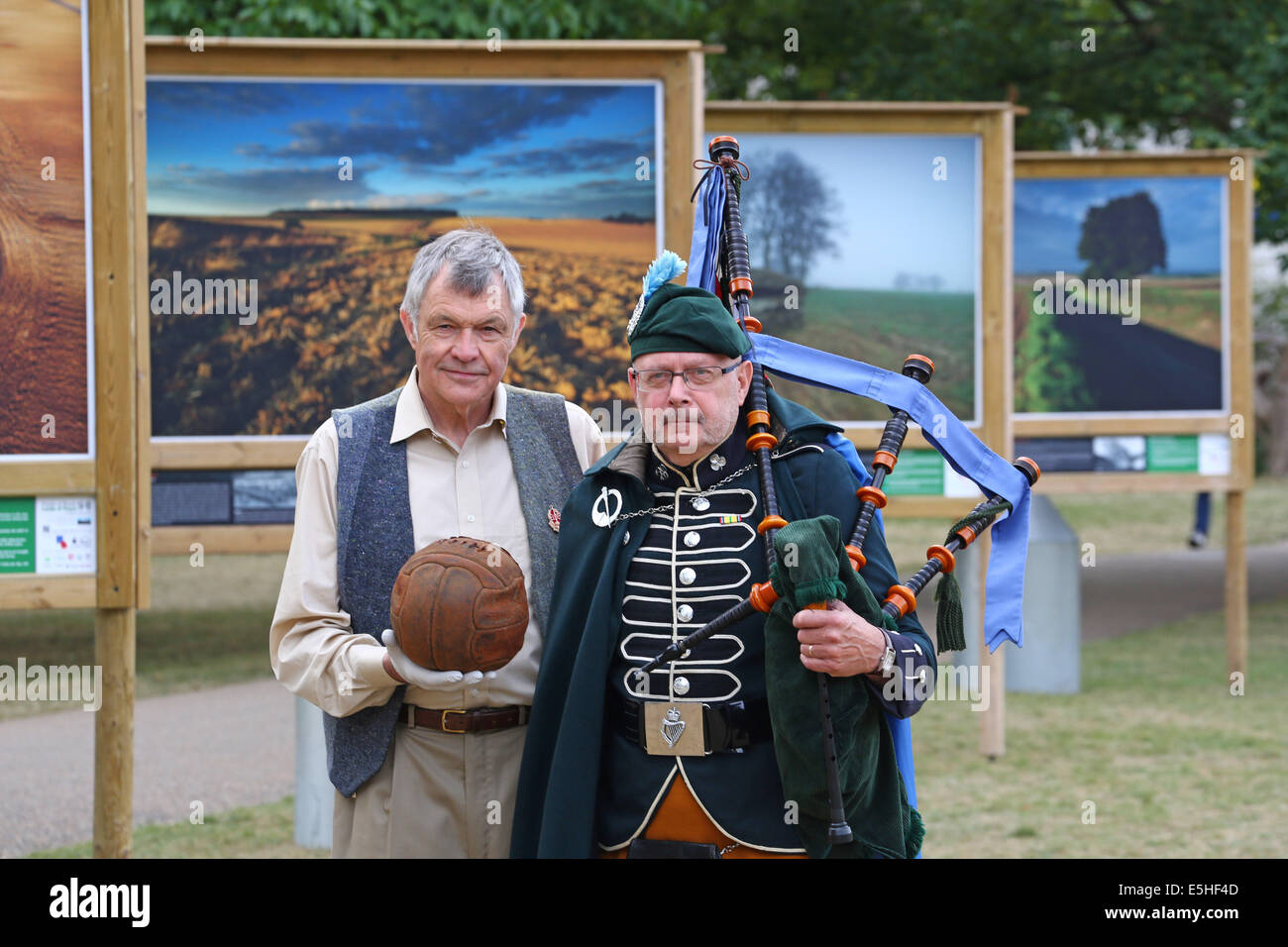 London, UK. 1. August 2014. Fotograf Mike St. Maur Sheil auf Felder der Schlacht Ländereien des Friedens 14-18 Ausstellung gesponsert The Royal British Legion im Freien in St. James' Park, London, England. Die Ausstellung erinnert an die Hundertjahrfeier des ersten Weltkriegs und beginnt am 4. August, zum 100. Geburtstag des ersten Weltkrieges in Großbritannien. Es läuft bis November.  Mike hält die Loos-Fußball, die die London Irish Rifles über No Mans Land am 25. September 1915 begann, wie sie die deutschen Stellungen in der Stadt von Loos angegriffen. Bildnachweis: Paul Brown/Alamy Live-Nachrichten Stockfoto