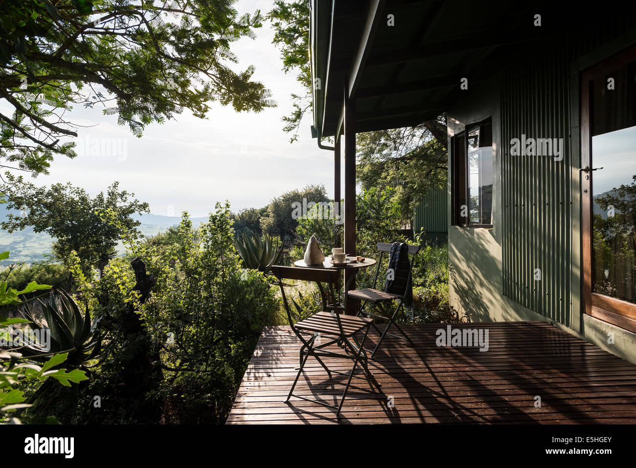 Frühstücks-Tisch und Stühle auf Hügel mit Hacienda außen Spioenkop, Kwa Zulu Natal, Südafrika Stockfoto