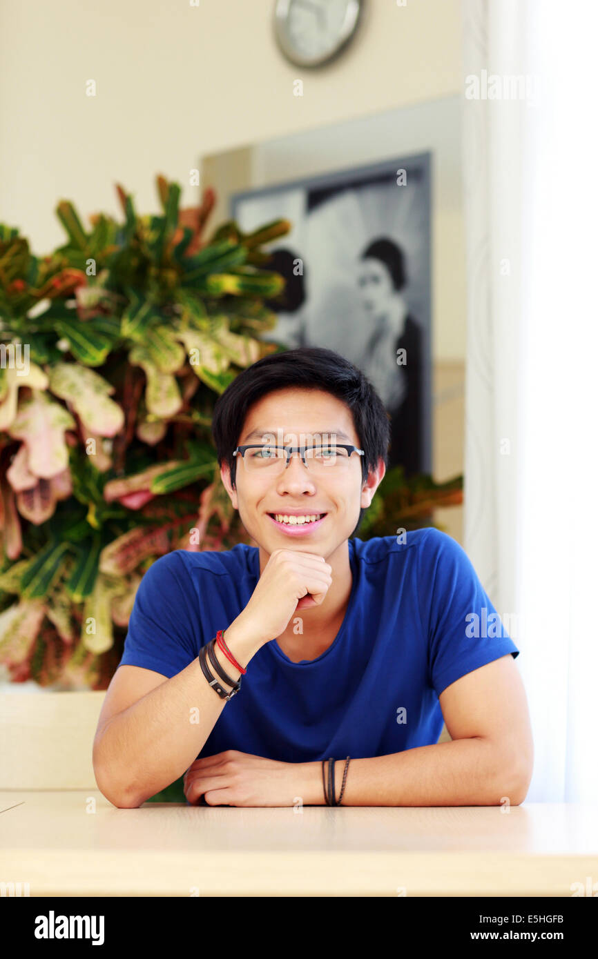 Glücklich asiatischen Mann mit Brille, die am Tisch sitzen Stockfoto