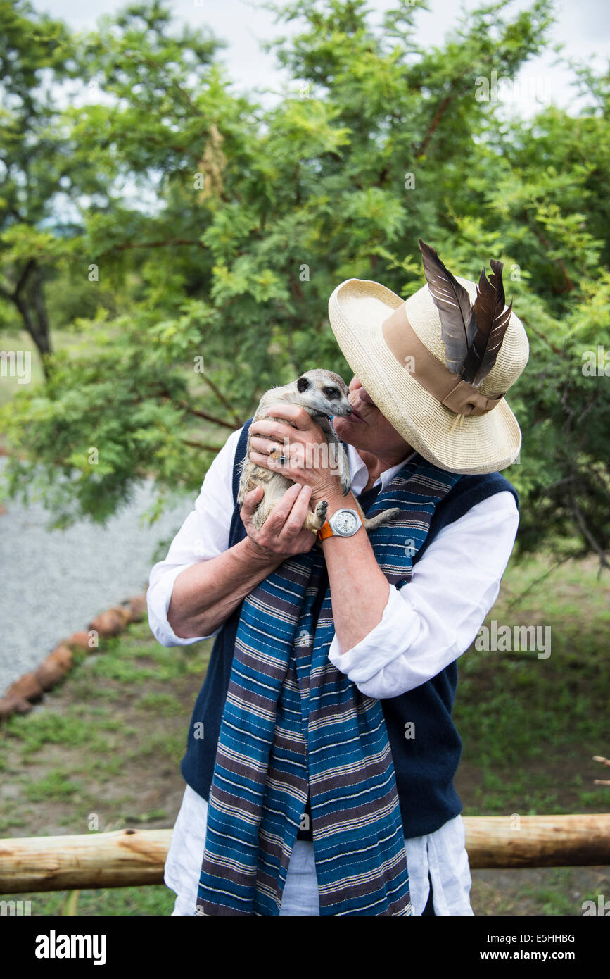 Nicht mehr wiederzuerkennen Frau küssen Erdmännchen (Suricata Suricatta) Nambiti Reserve, Kwa-Zulu Natal, Südafrika Stockfoto