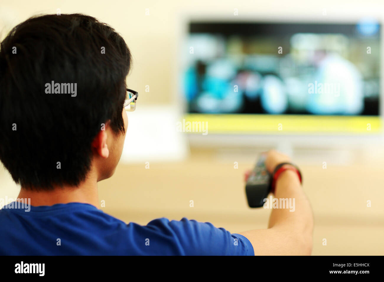 Rückansicht Porträt eines Mannes vor dem Fernseher zu Hause im Wohnzimmer Stockfoto