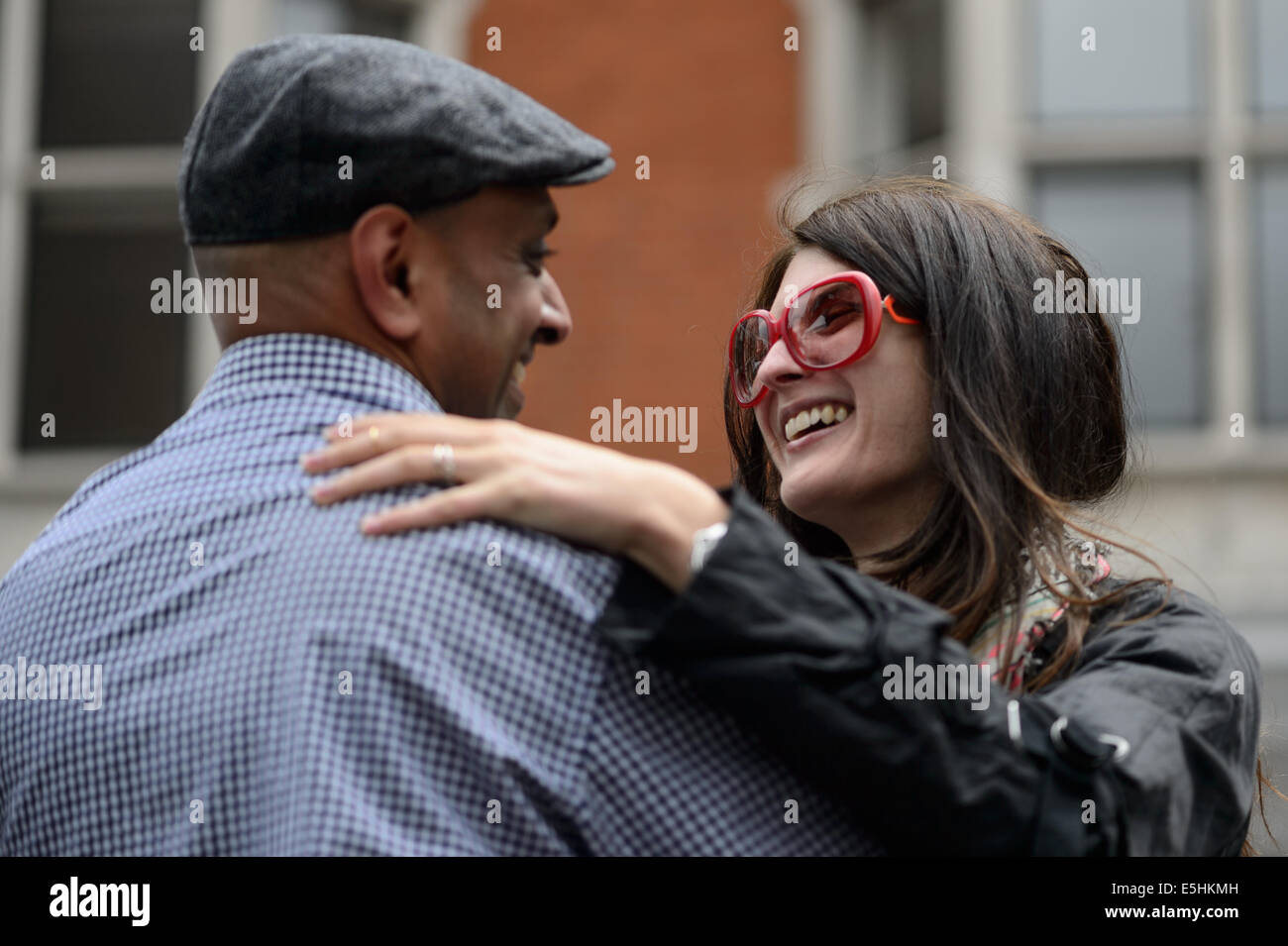 Ein junges Paar teilen eine liebevolle Umarmung beim tanzen Samba in der Öffentlichkeit während Marylebone Street Sommer Fayre, London, UK. Stockfoto