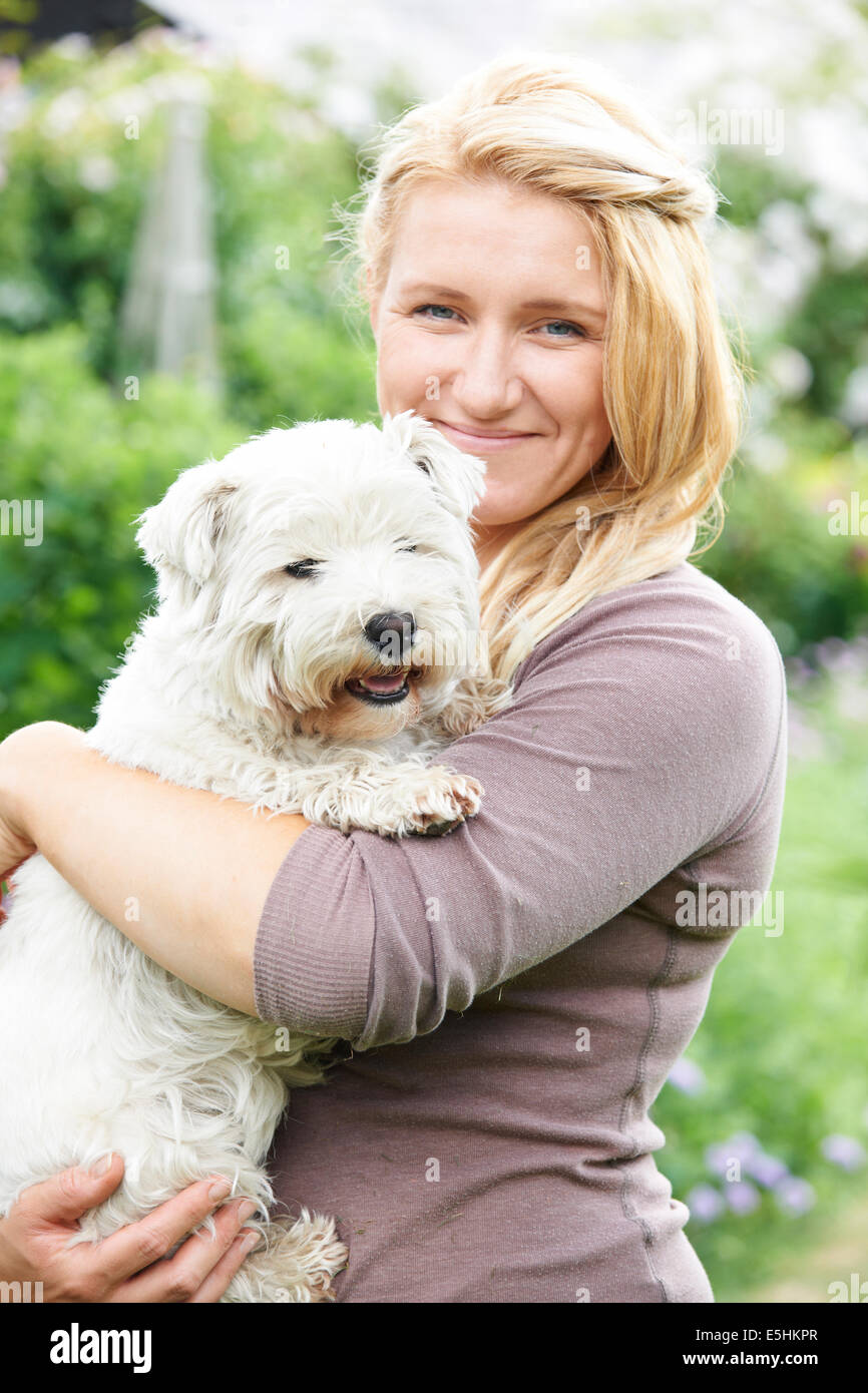 Portrait von Frau mit Hund im Garten Stockfoto