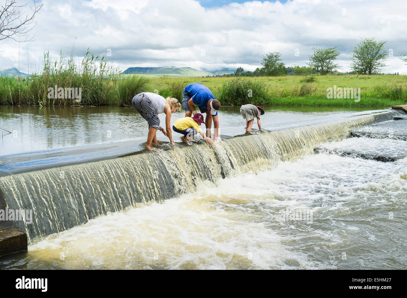 Vierköpfige Familie erkunden Fluss-Wehr Stockfoto