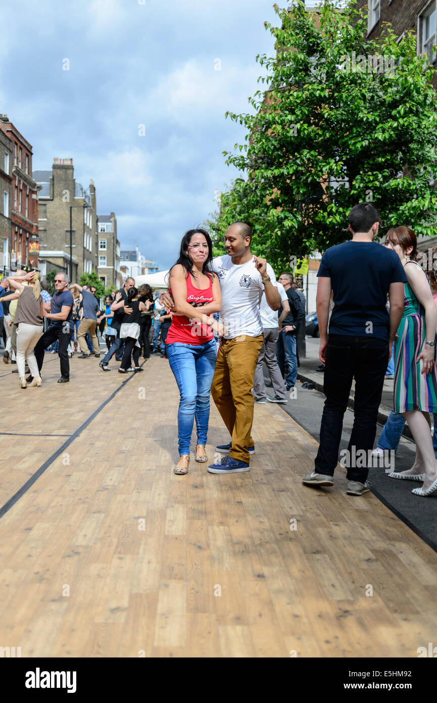 Ein attraktives junges Paar 20-30er Jahren zeigen einige Tanzbewegungen auf einem öffentlichen Tanzfläche in Marylebone Street Sommer Fayre, London, UK. Stockfoto