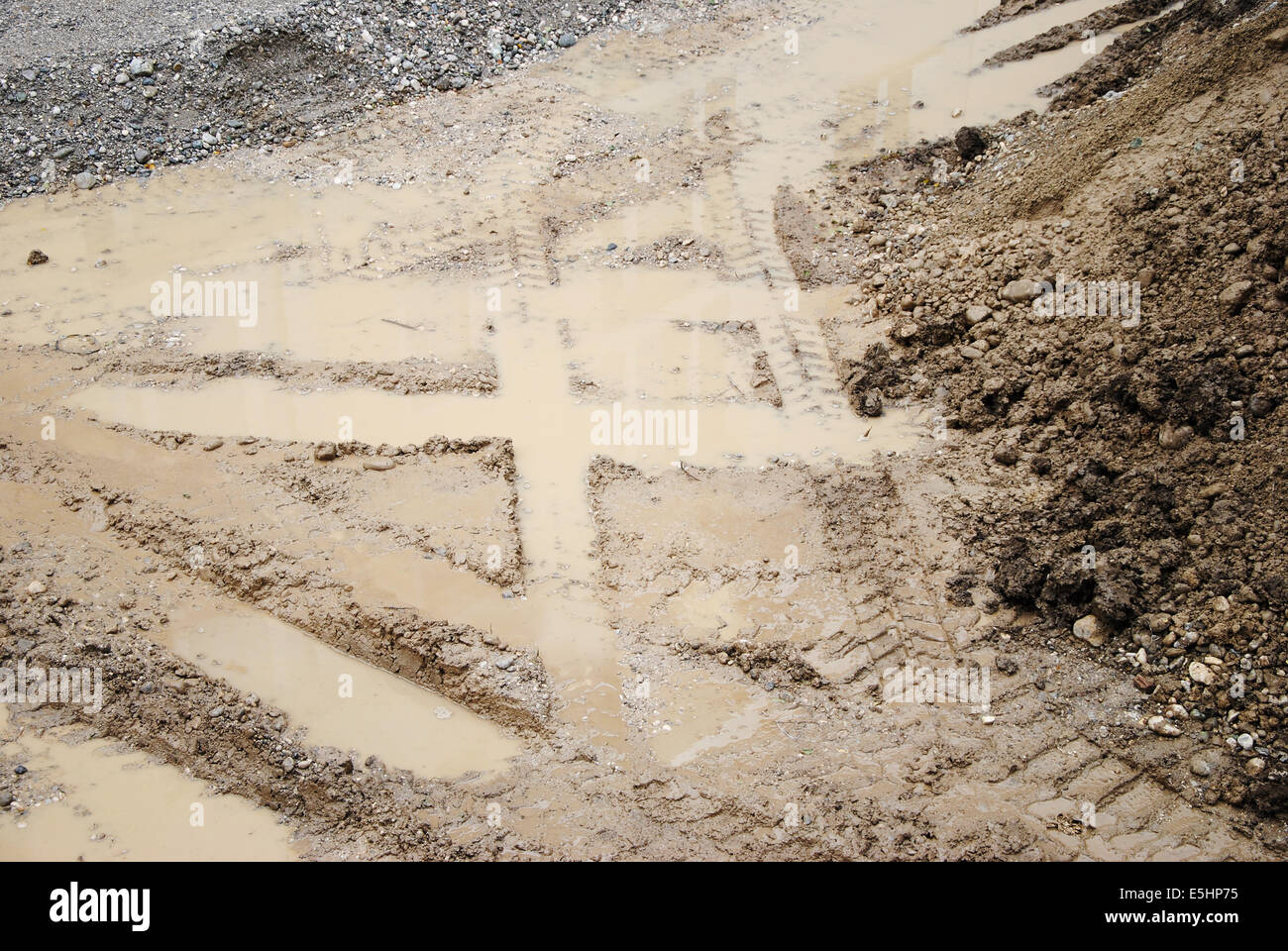 Reifenspuren auf Sand, Nahaufnahme einer Baustelle mit Reifenspuren, Sand, Dreck und Pfützen Stockfoto