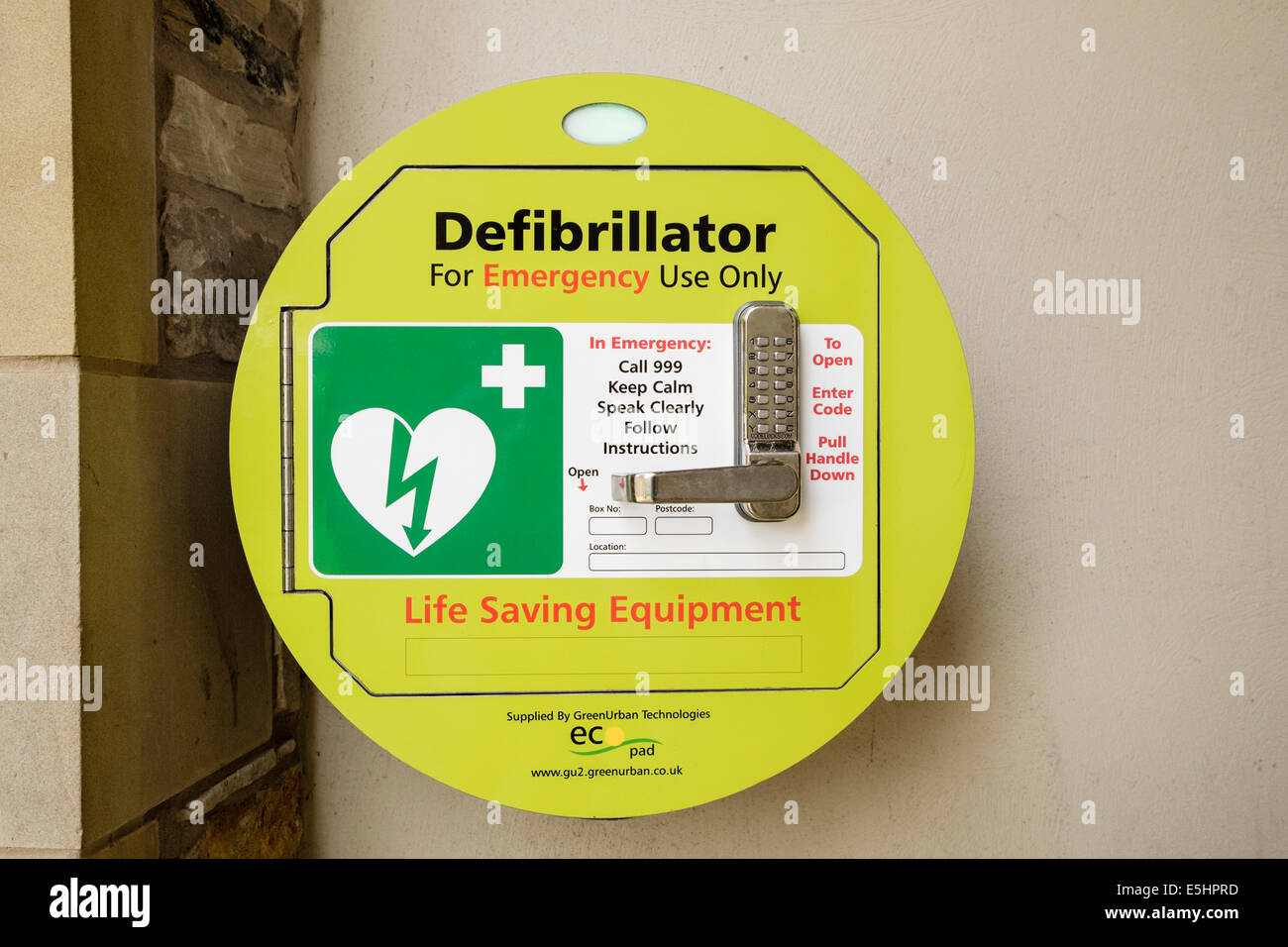 Notfall Herz Defibrillator lebensrettende Ausrüstung für Herzstillstand mit Code Sperre Wand montiert für die öffentliche Nutzung. England-UK Stockfoto