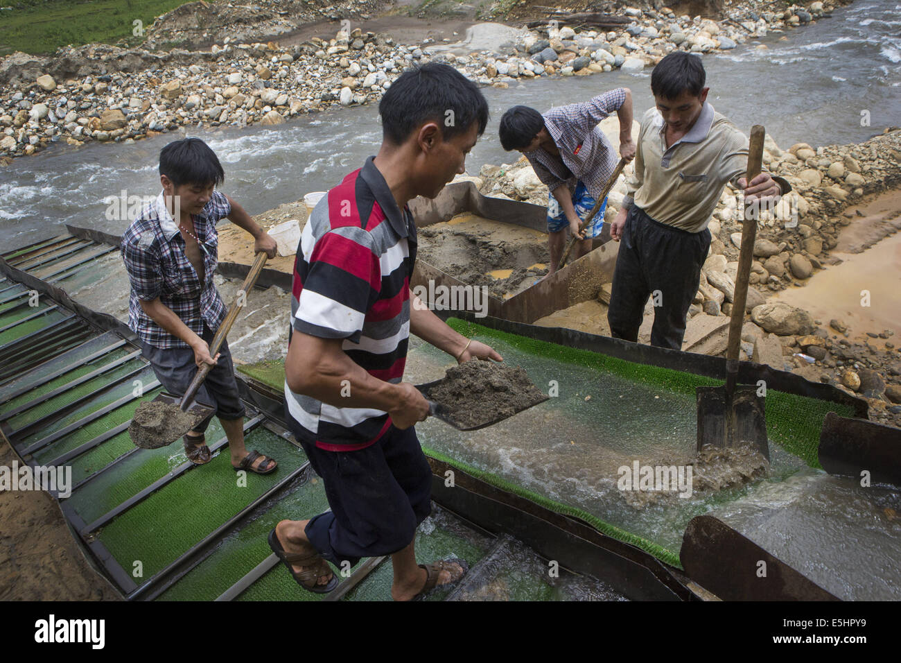 9. Juli 2014 - Laiza, Kachin, Myanmar - chinesische Goldgräber Schaufeln schweren Schlamm für einen zweiten Durchgang, die leichteren Elemente von den schwereren an einem gold-Bergbau-Standort in der Nähe von Laiza, Kachin State in Myanmar zu trennen. Im Mineral-reiche Gebiete der Kachin-Staat Steuern aus Birma und chinesischen Goldminen bietet eine wichtige Einnahmequelle für die Kachin Unabhängigkeit Organisation. Jedoch verwenden diese Bergbauunternehmen Quecksilber in einer umweltgefährdenden Extraktionsprozess, was zu dauerhaften Schäden für des Bereich Wald und Fluss Möglichkeiten führen kann. (Kredit-Bild: © Taylor Weidman/ZUMA Draht) Stockfoto