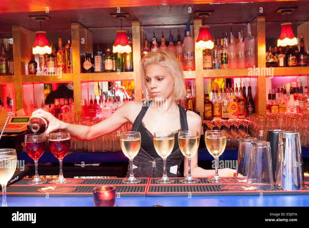 Junge Kellnerin serviert Wein, London, England, UK Stockfoto
