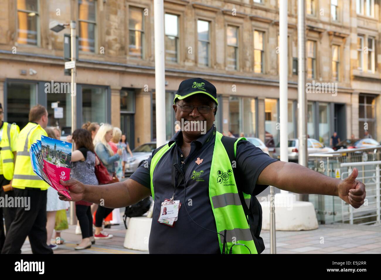 Gastgeberstadt Volunteer bietet einen Empfang für die Besucher der Glasgow Commonwealth Games. Stockfoto