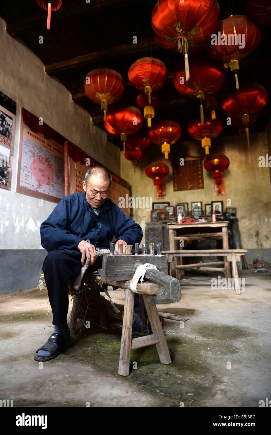 Yudu, Chinas Jiangxi Provinz. 1. August 2014. Stroh Sandale Handwerker Chen Luoshou webt Stroh Sandalen, in Buqian Dorf Luoao Township in Yudu County, Osten Chinas Jiangxi Provinz, 1. August 2014. Chen Luoshou, der 78 Jahre alt ist, ist eine der wenige Handwerker in der Lage Stroh Sandalen in Yudu County zu weben. Obwohl niemand Sandalen Stroh heutzutage die siebzigjährige noch in der Weberei Stroh Sandals jeden Tag beibehalten. Ein paar Stroh Sandalen kostet des alten Mannes zwei Stunden und sie werden in der Regel an Touristen oder Messehallen mit 30 Yuan (4,85 US-Dollar) verkauft. © Chen Zixia/Xinhua/Alamy Live-Nachrichten Stockfoto