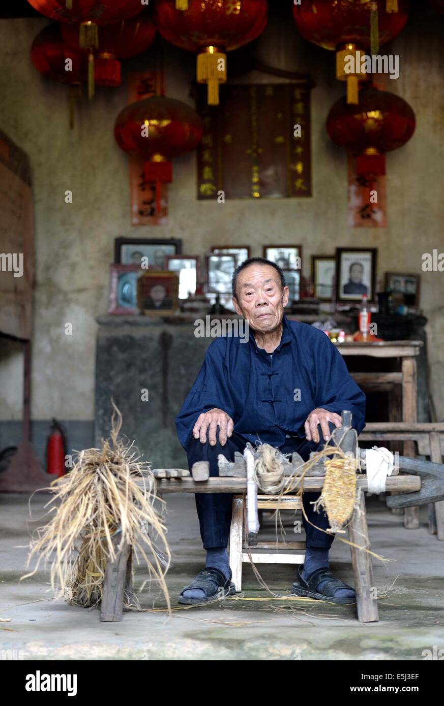 (140802)--YUDU, 2. August 2014 (Xinhua)--Stroh Sandale Handwerker Chen Luoshou für posiert Fotos mit seinem Stroh Sandalen weben Werkzeuge in Buqian Dorf Luoao Township in Yudu County, Osten Chinas Jiangxi Provinz, 1. August 2014. Chen Luoshou, der 78 Jahre alt ist, ist eine der wenige Handwerker in der Lage Stroh Sandalen in Yudu County zu weben. Obwohl niemand Sandalen Stroh heutzutage die siebzigjährige noch in der Weberei Stroh Sandals jeden Tag beibehalten. Ein paar Stroh Sandalen kostet des alten Mannes zwei Stunden und sie werden in der Regel an Touristen oder Messehallen mit 30 Yuan (4,85 US-Dollar) verkauft. (Xinhua / Stockfoto